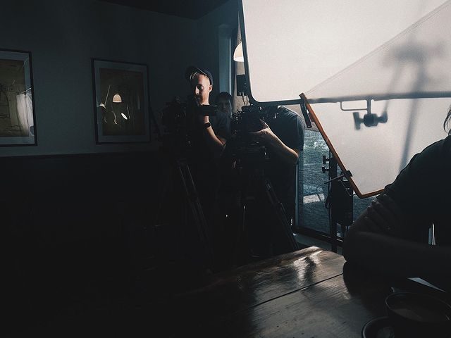 Lighting and camera setup inside a dimly lit interior location